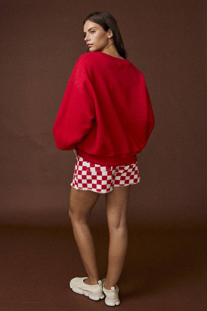Woman wearing a red sweatshirt with Gameday in White stitching on front and solid red in back.