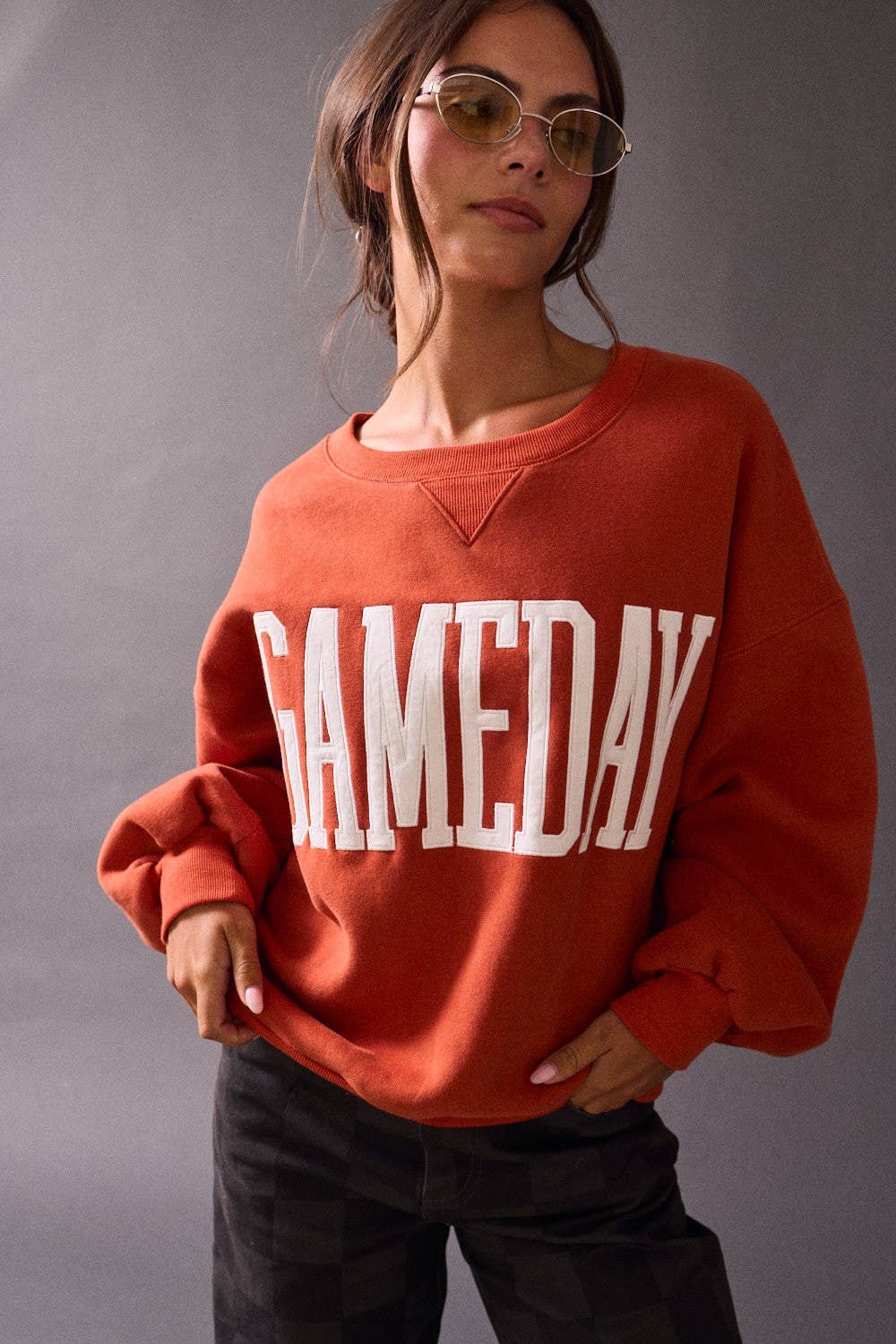 Person wearing a red 'GAMEDAY' sweatshirt against a gray background